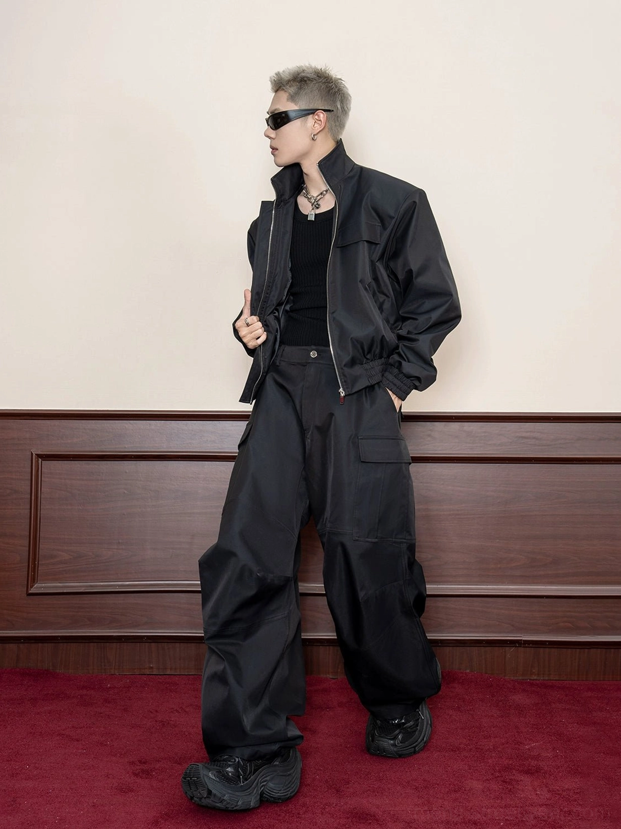 Black oversized utility jacket side view styled with wide-leg cargo pants and black work boots in Seoul streetwear look