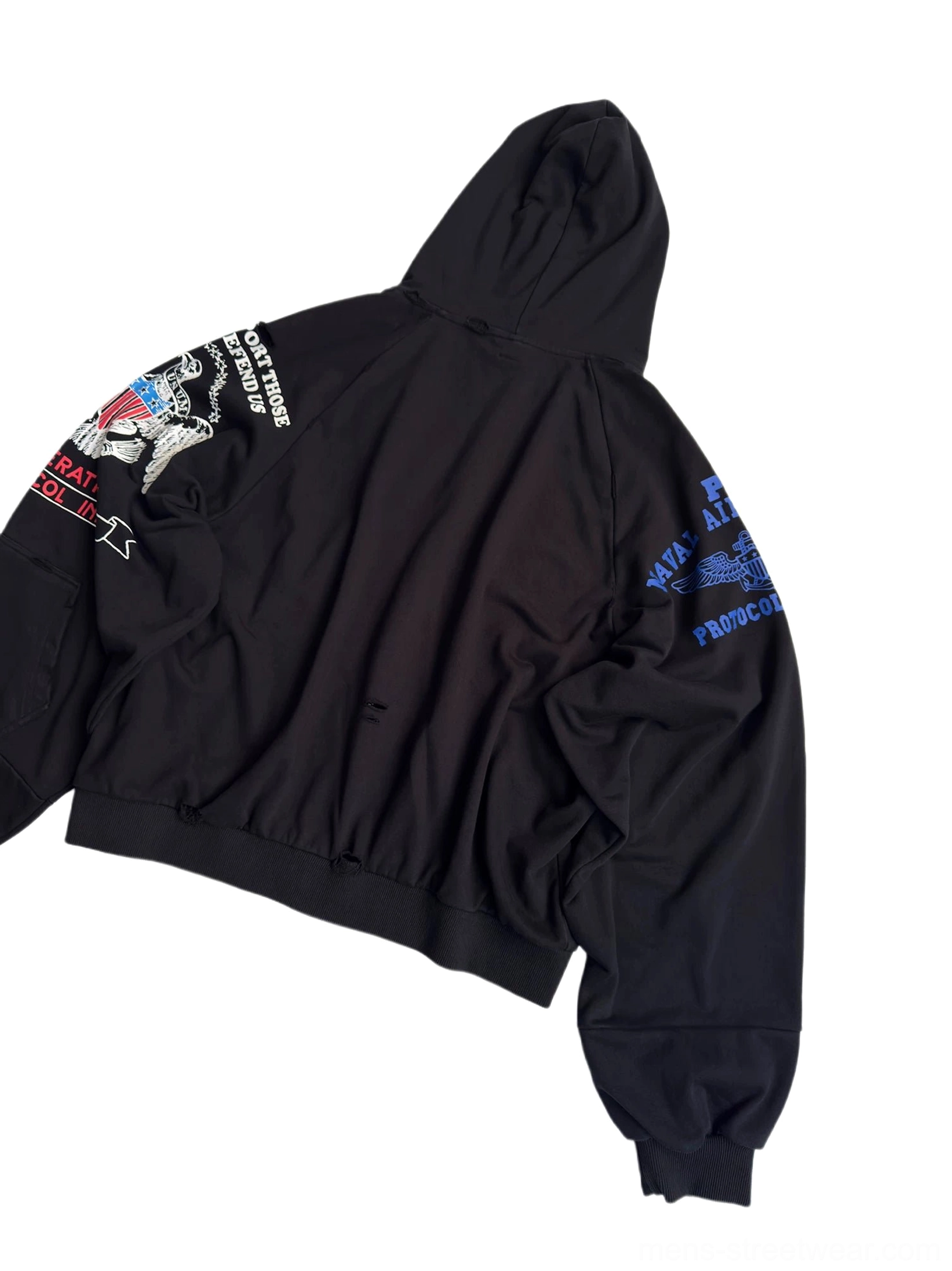 Back left view of oversized black varsity zip-up hoodie displaying colorful embroidery on both sleeves and relaxed dropped-shoulder silhouette
