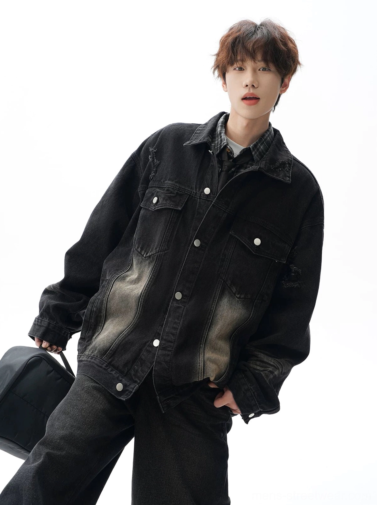 Black oversized vintage denim jacket in a low three-quarter view with faded wash, chest pockets, wide-leg denim styling, and urban streetwear attitude