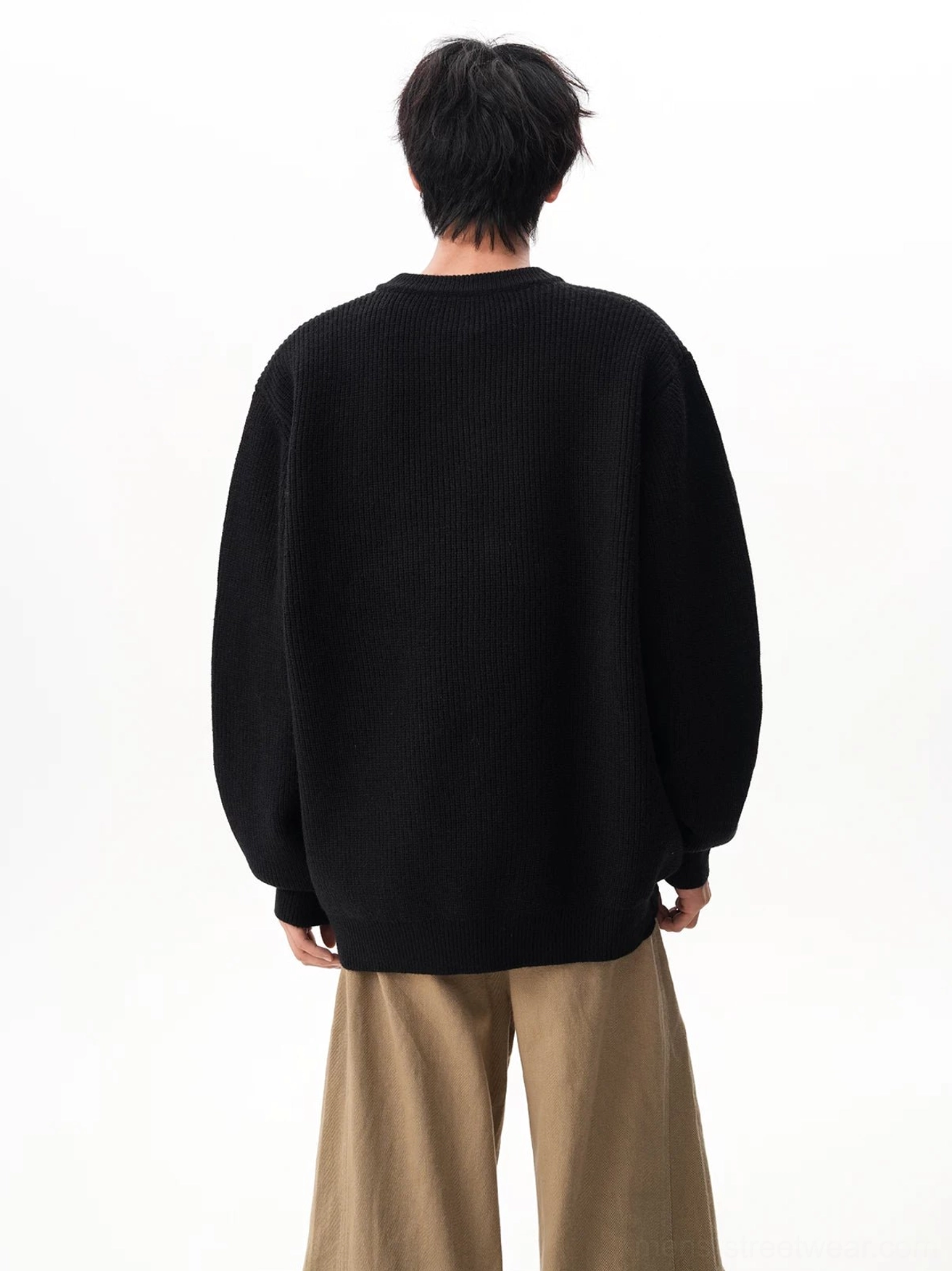 Back view of a black oversized waffle Henley knit sweater with a relaxed streetwear fit and clean ribbed texture