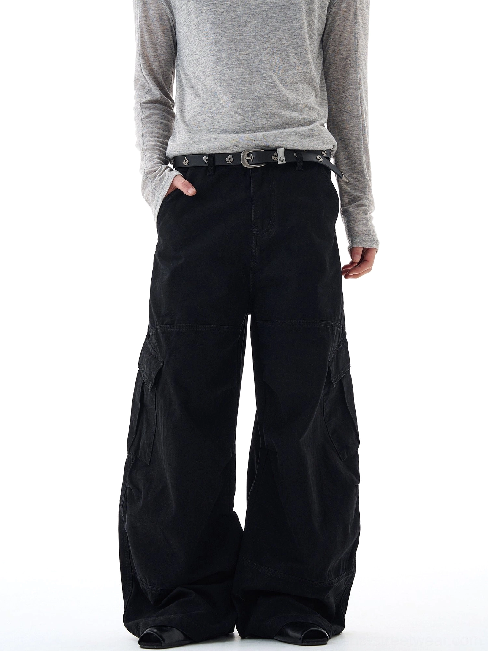 Black oversized wide-leg cargo pants shown from the front with matte cotton fabric, side utility pockets, and relaxed streetwear fit