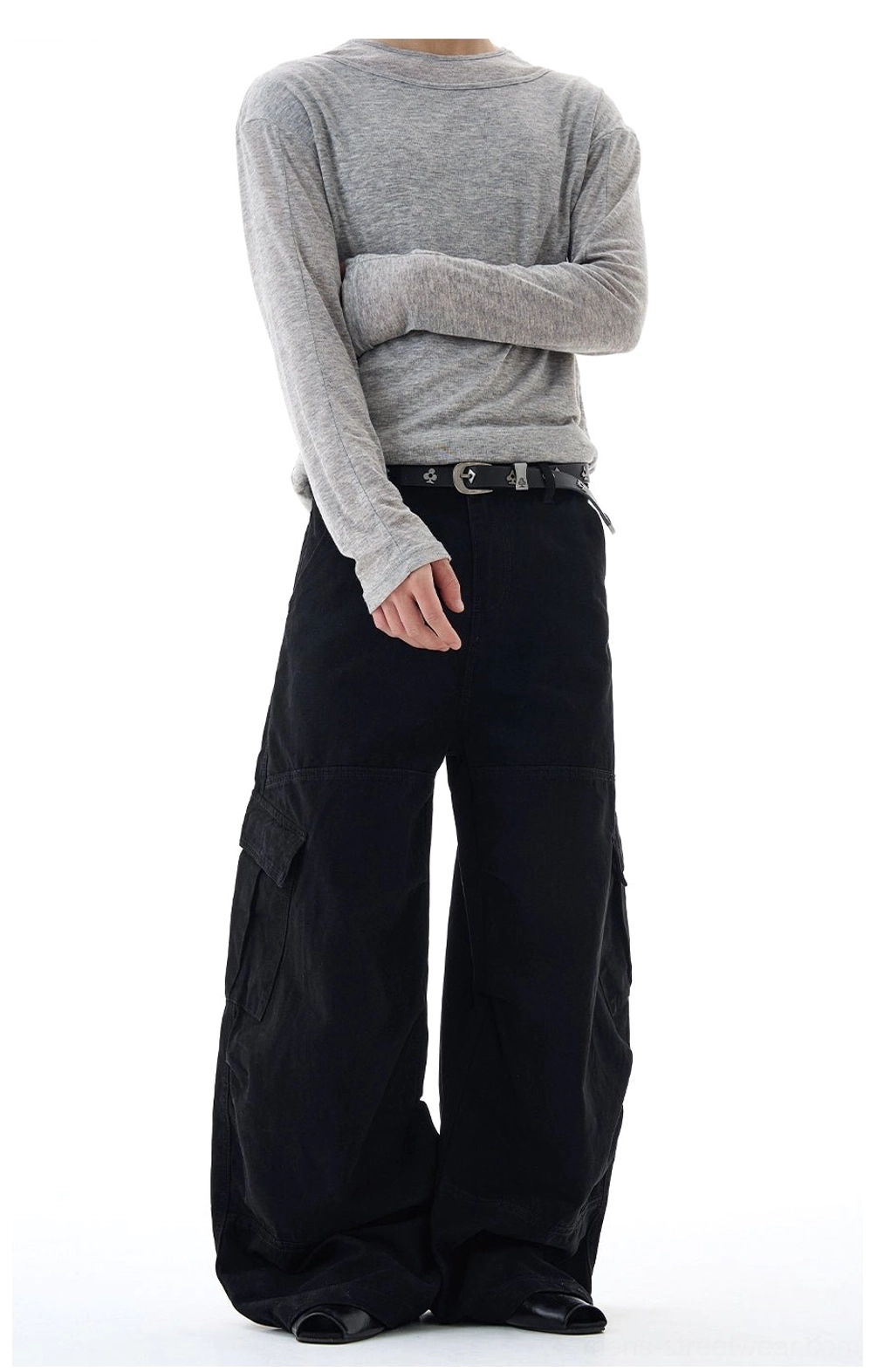Side rear view of black oversized wide-leg cargo pants highlighting the relaxed drape, utility pocket design, and casual streetwear silhouette