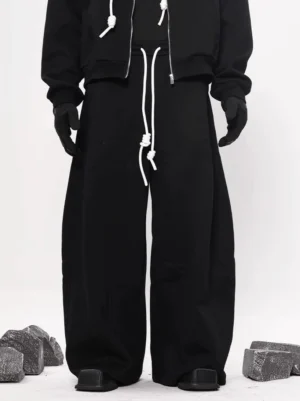 Black oversized wide leg fleece sweatpants shown from the front with dual white drawstrings, wide straight legs, and modern Seoul streetwear styling