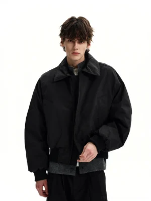 Black padded bomber jacket front view on male model with relaxed drop shoulders ribbed cuffs and Korean streetwear styling