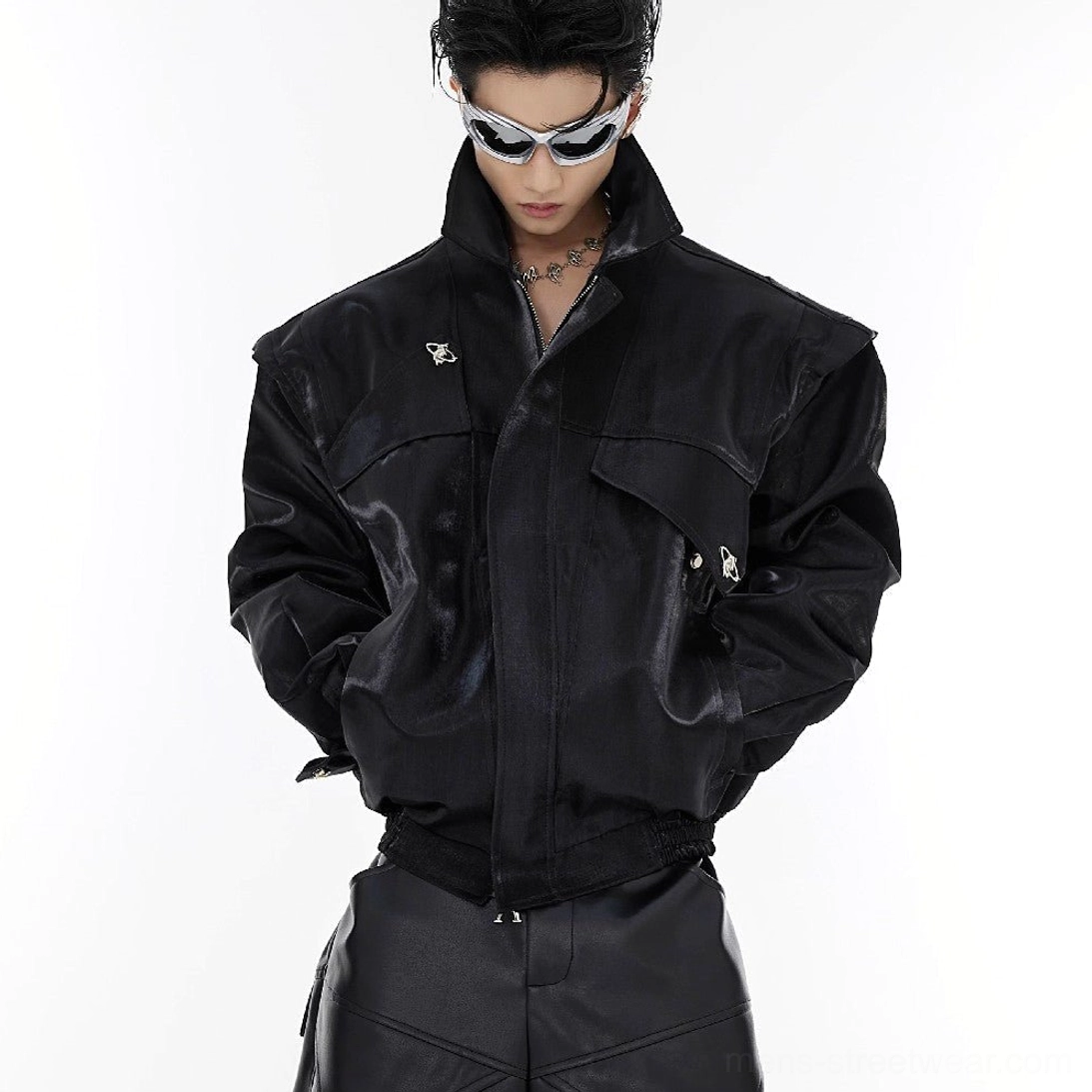 Black padded shoulder vegan leather jacket close-up with front zipper, flap pockets, metal buckles and structured cropped fit