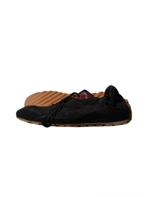 Black paneled nubuck low-profile trainers with tan gum outsole, offset lacing, red contrast stitching, and maroon insole