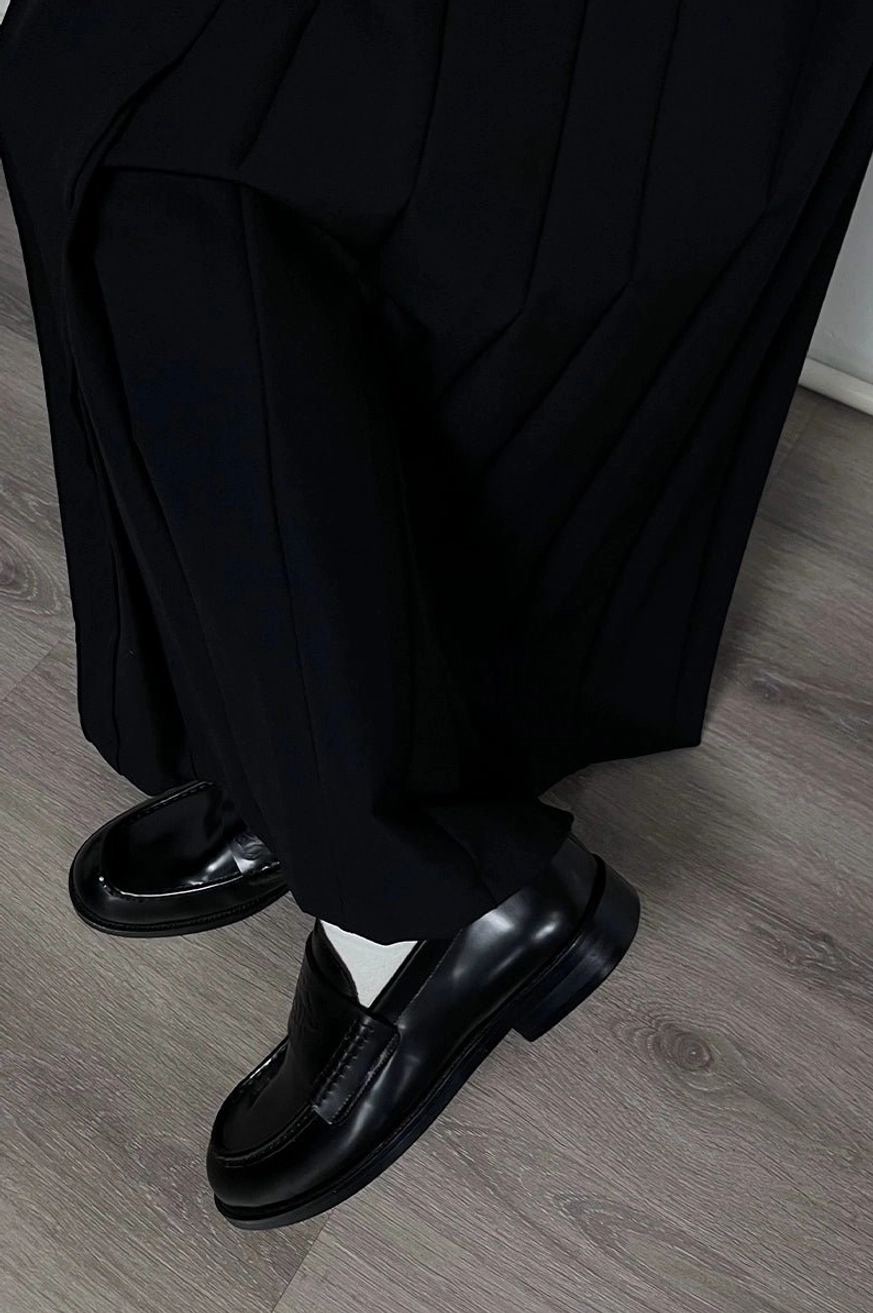 Black embossed patent leather loafers worn with black tailored trousers and white socks for a Seoul streetwear inspired outfit