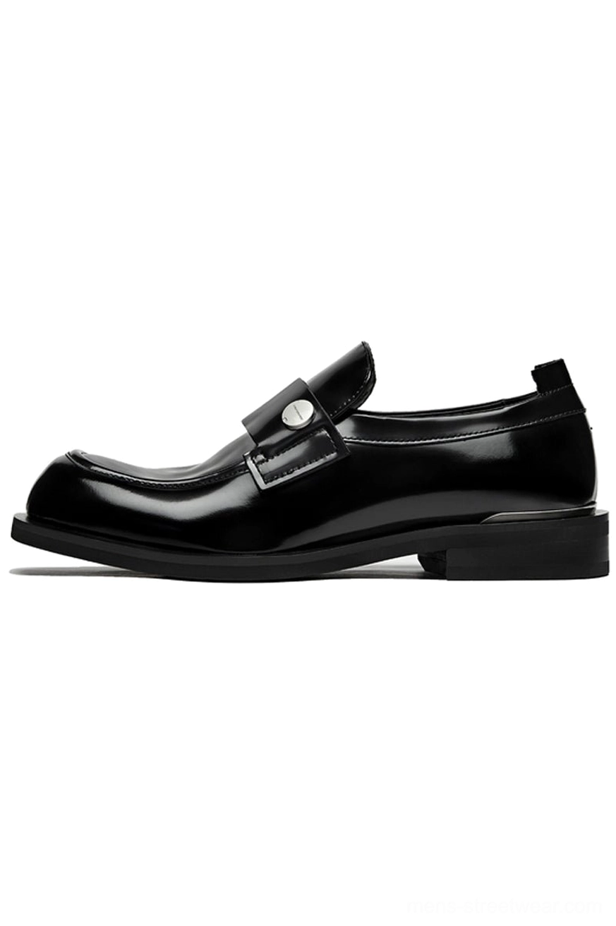 Black patent leather penny loafers with glossy square toe silver metal strap and metallic heel detail on a white background