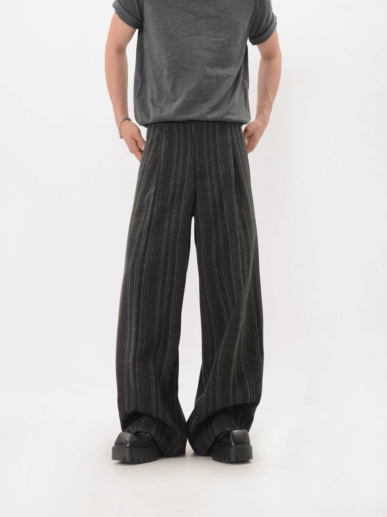 Front view of black pinstripe wide-leg streetwear trousers with pleated waist and full-length hem