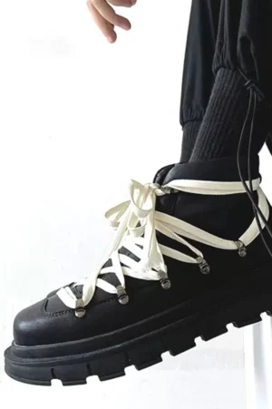 Black platform combat boots worn with black cargo pants and ribbed socks in minimalist streetwear styling