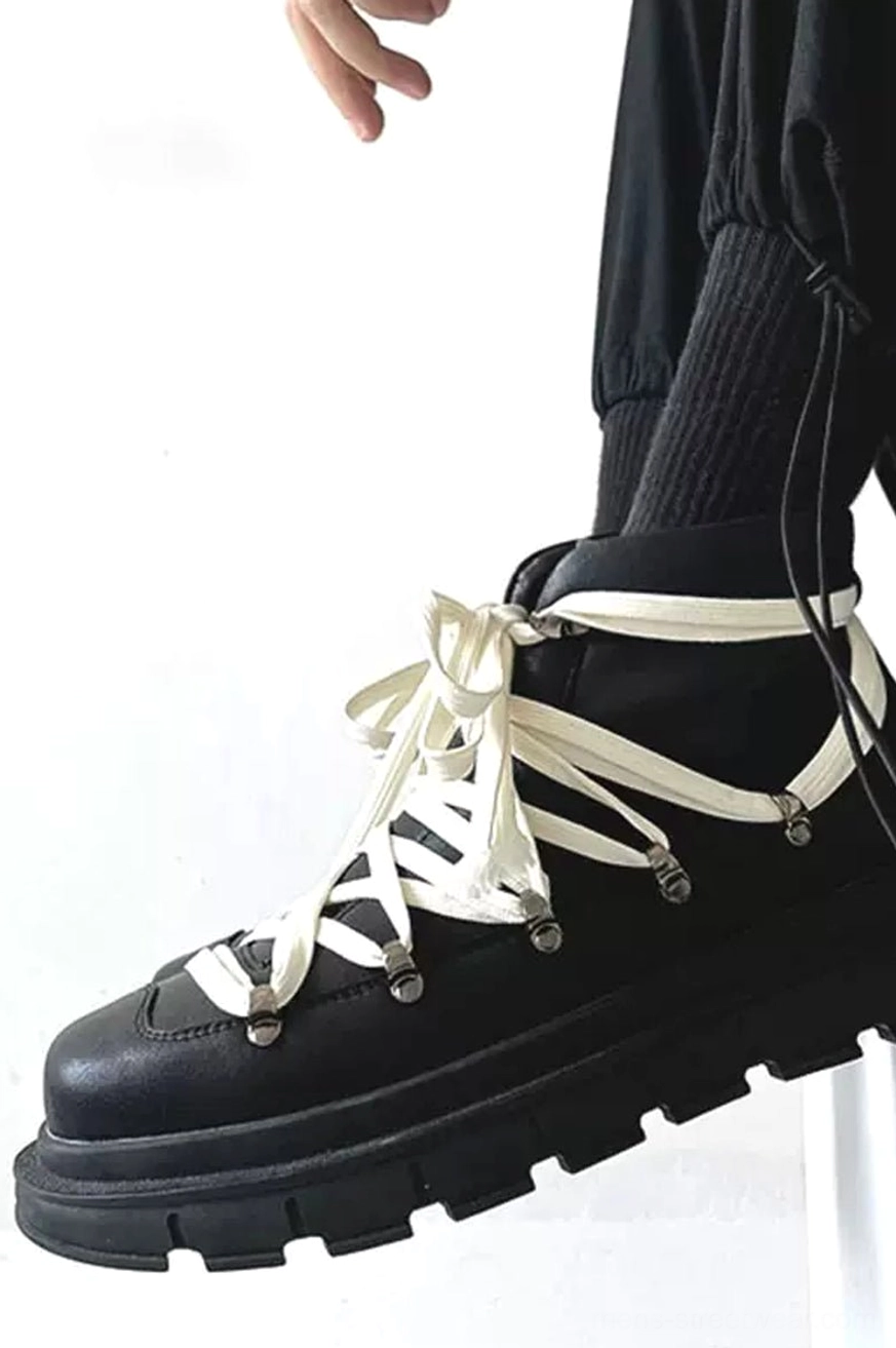 Black platform combat boots worn with black cargo pants and ribbed socks in minimalist streetwear styling