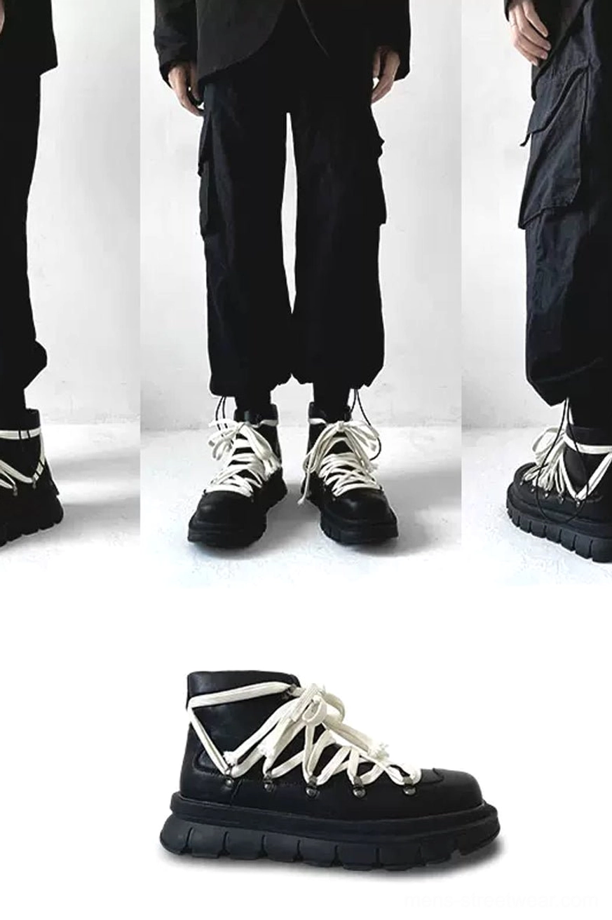 Rear side view of black platform combat boots worn with black cargo pants showing thick rubber lug sole