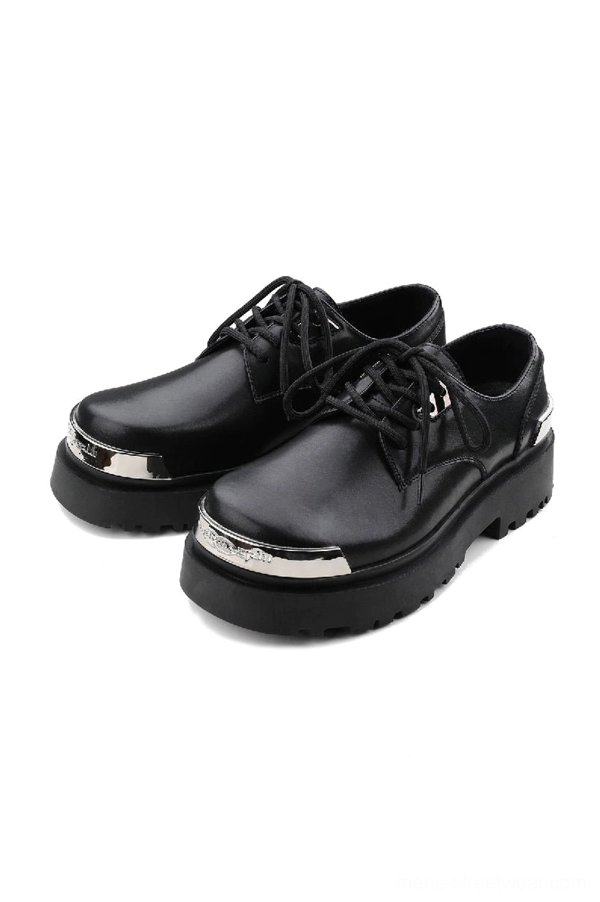 Black platform derby shoes with glossy two-layer cowhide upper, silver metal toe caps, lace-up front, and thick lug rubber outsole on a white studio background