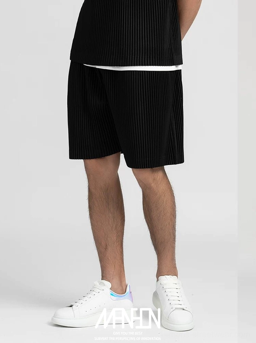 Black pleated casual tech shorts with loose straight legs styled with clean white low top sneakers