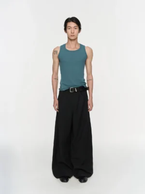 Black pleated wide-leg trousers shown in a full-body front view with a relaxed Korean streetwear silhouette and smooth matte suiting fabric