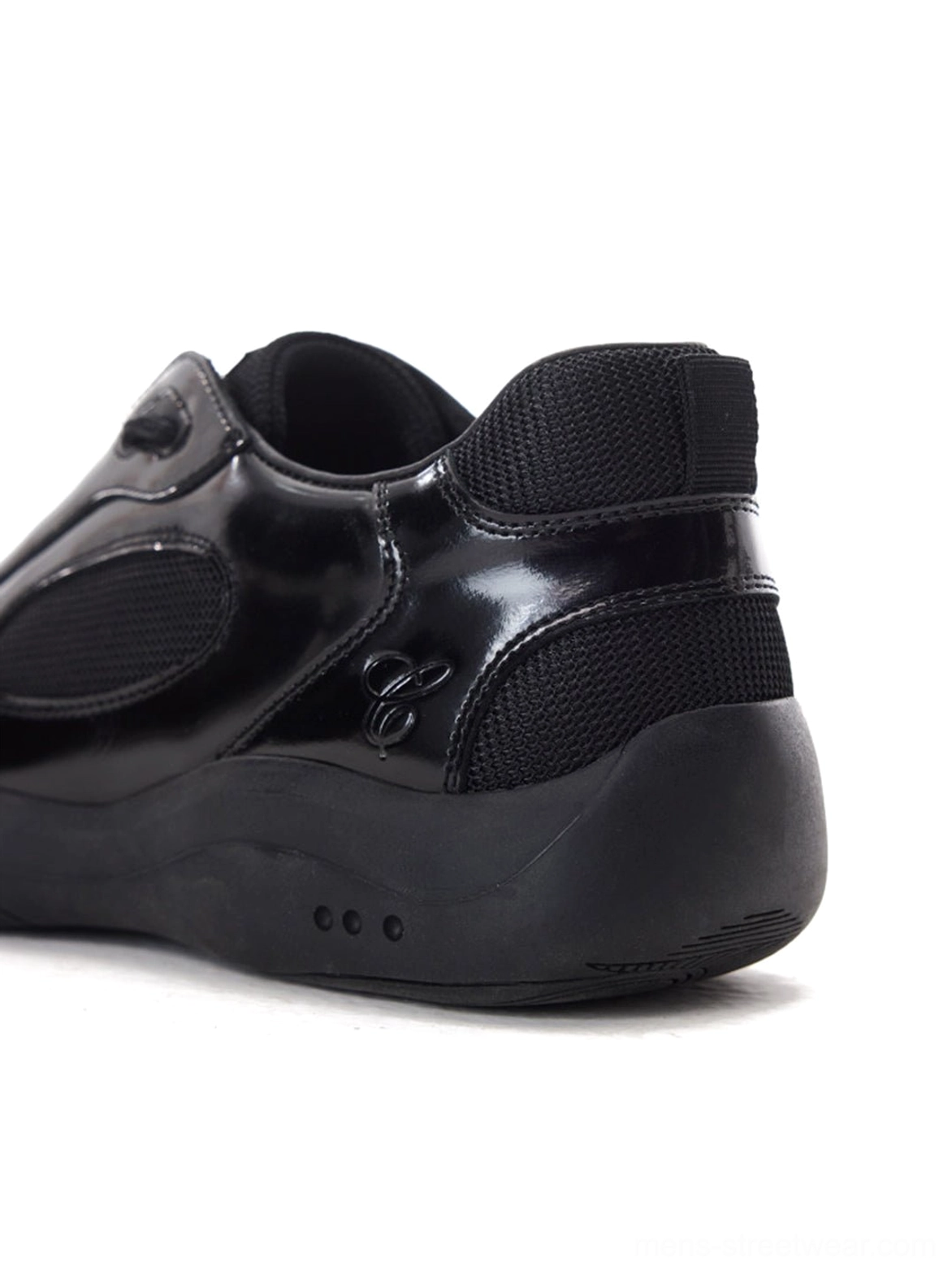 Rear three-quarter view of black polished leather retro runner sneakers with mesh heel counter padded heel tab and metal side detail