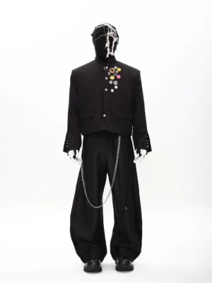 Full front view of black punk cropped blazer and wide-leg trousers set with colorful badge details and silver waist chain