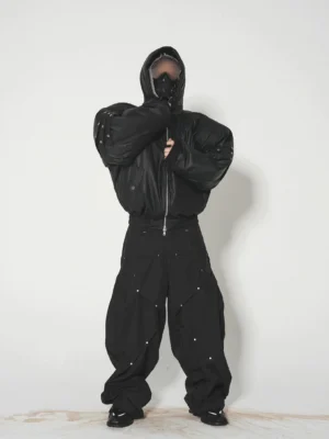 Front view of black quilted hooded puffer bomber jacket with silver sleeve studs and full zip closure