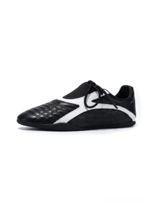 Black quilted panel flat-sole sneakers shown from the left side with white contrast inserts, black flat laces, and a low-profile rubber sole on a clean white background