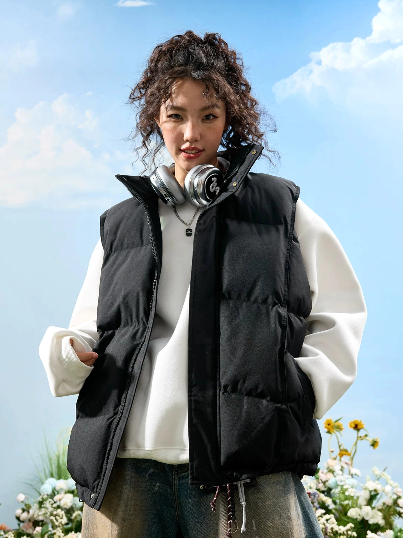 Black oversized quilted puffer vest styled with a white sweatshirt and loose jeans in a casual Korean streetwear outfit