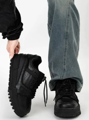 Black Rampart chunky platform sneakers with crocodile embossed leather upper, rugged lug sole, lace-up design, baggy blue jeans and black streetwear jacket
