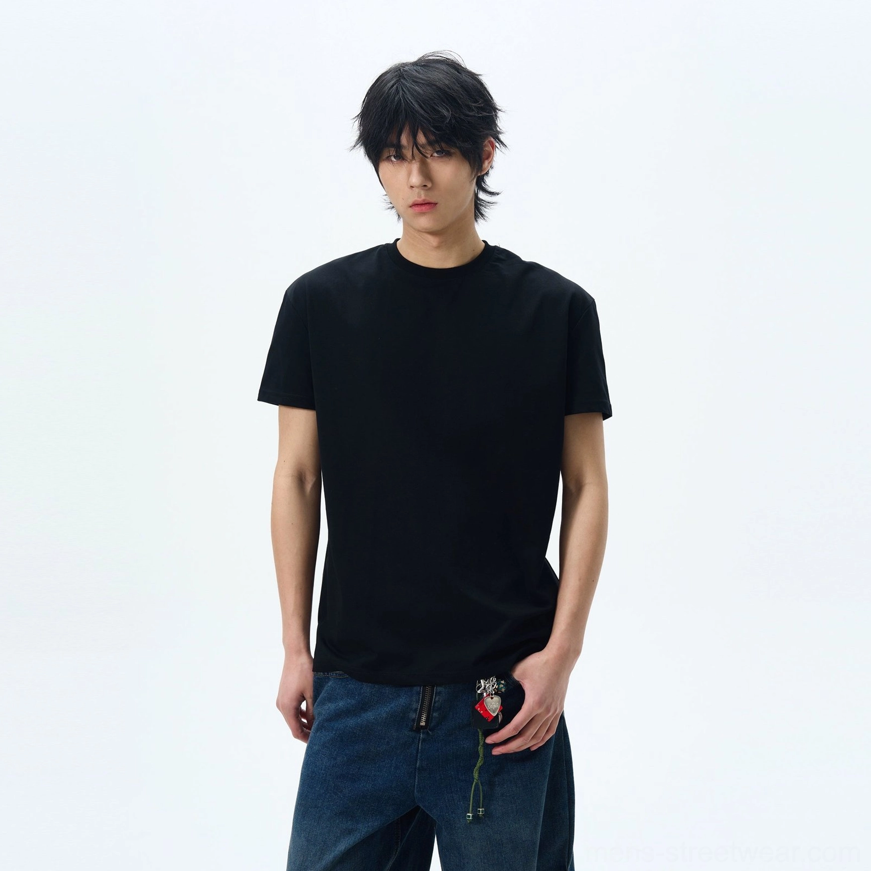 Black relaxed crew neck t-shirt styled with jeans and a rose-shaped hanging waistband ornament