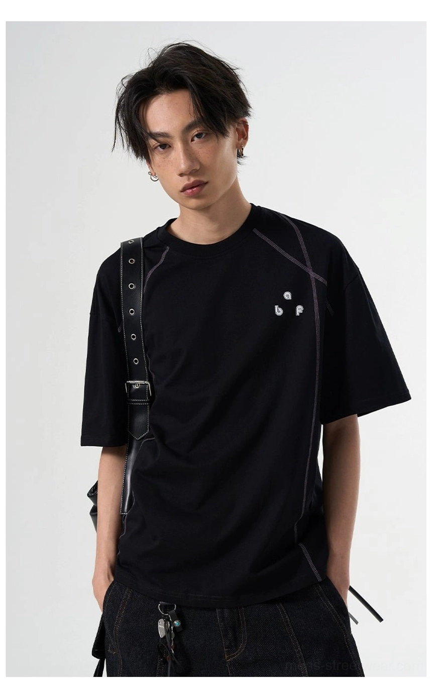 Black relaxed fit graphic tee with dark contrast seams and crossbody bag streetwear styling
