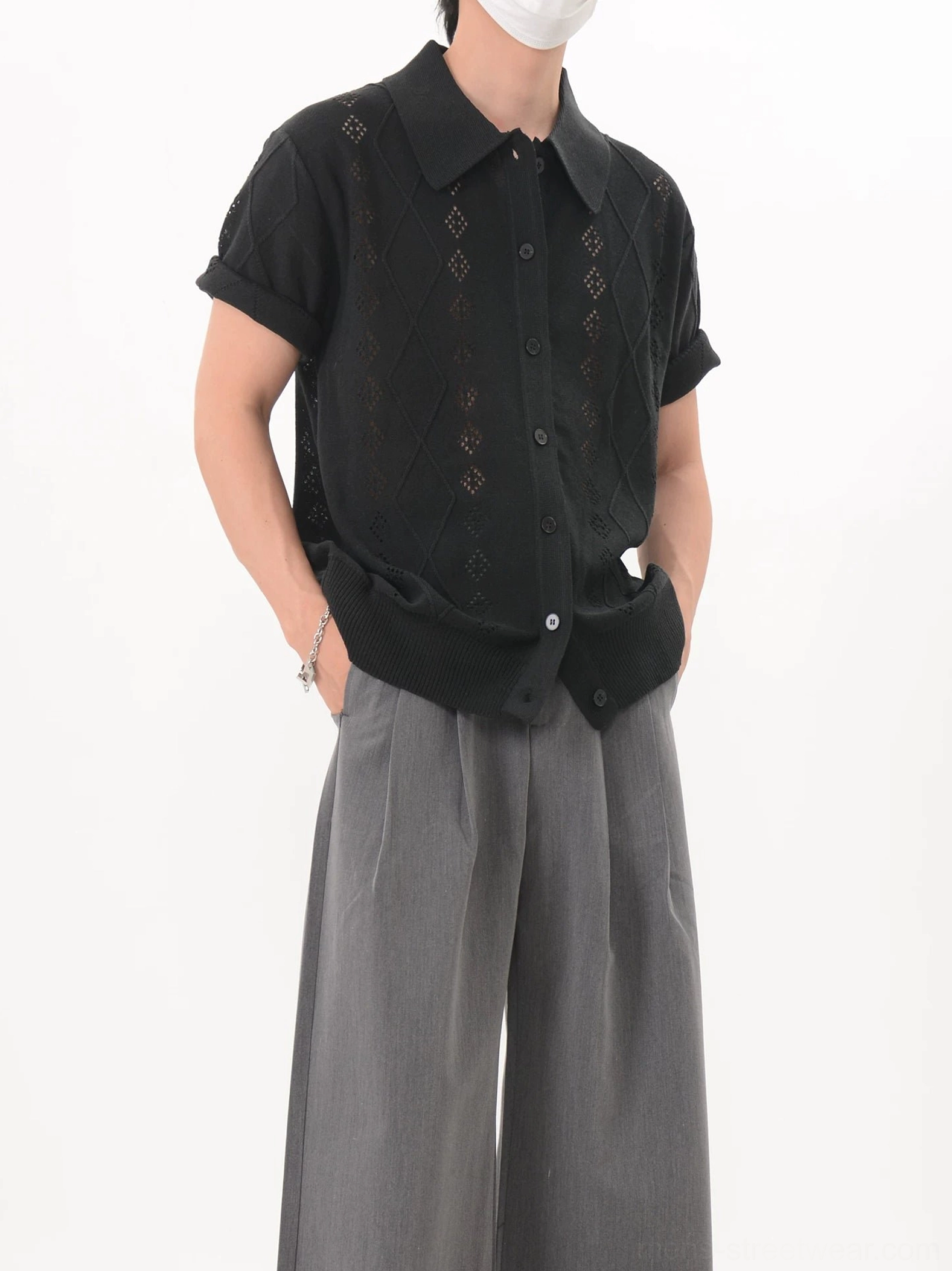 Black relaxed-fit openwork knit polo cardigan shown from the side with a turn-down collar and short sleeves