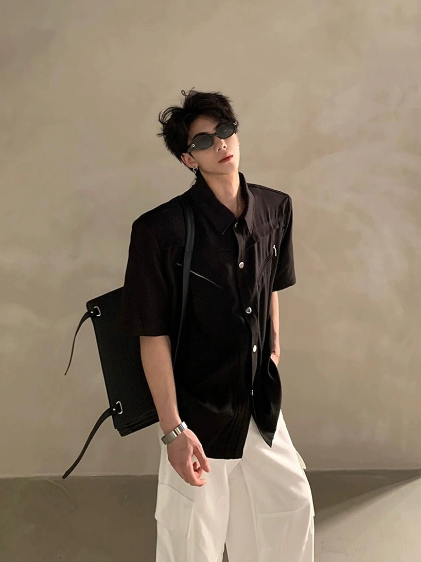 Black relaxed fit short sleeve shirt with solid color finish, front button closure, pointed collar, sunglasses, and white cargo pants