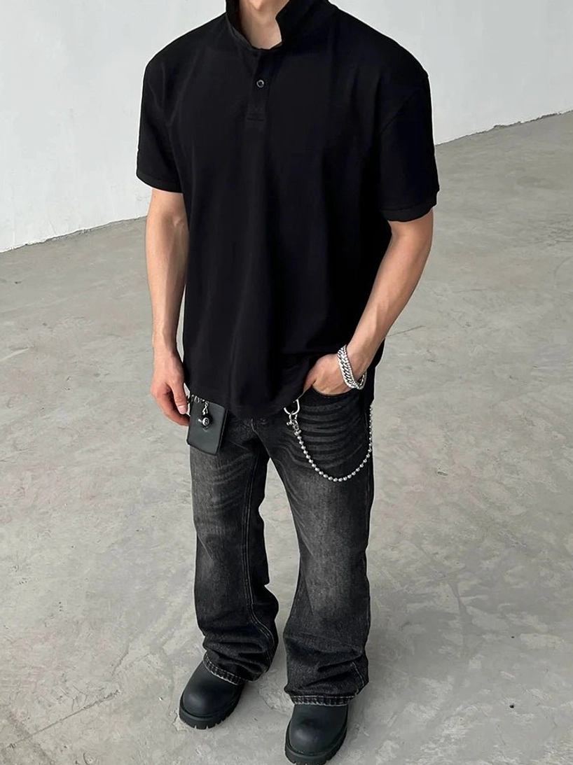 Black relaxed-fit stand-collar polo shirt with short sleeves and single-button placket styled for modern minimalist streetwear