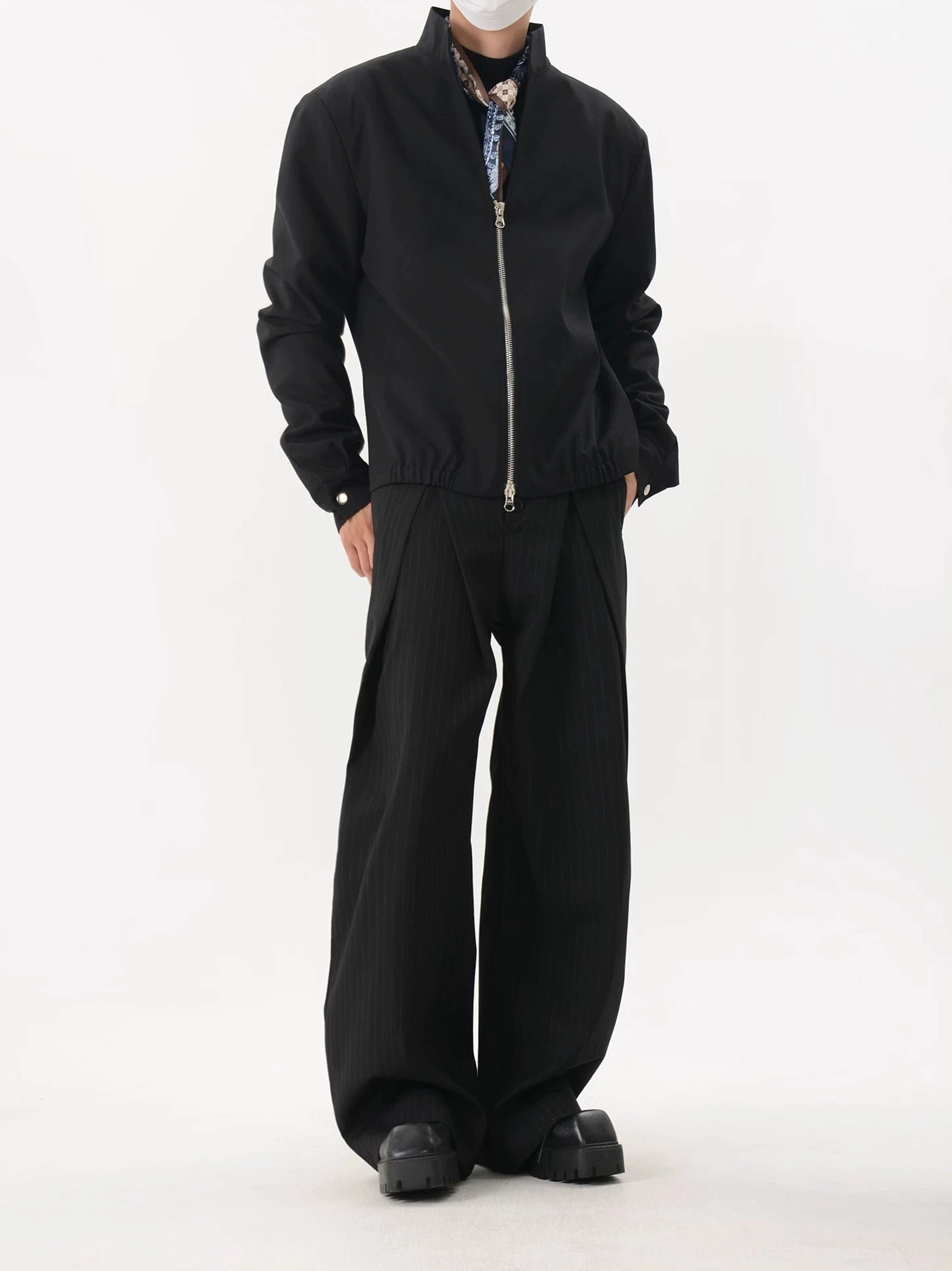 Black relaxed-fit stand collar blouson jacket back view showing gathered hem and streetwear silhouette