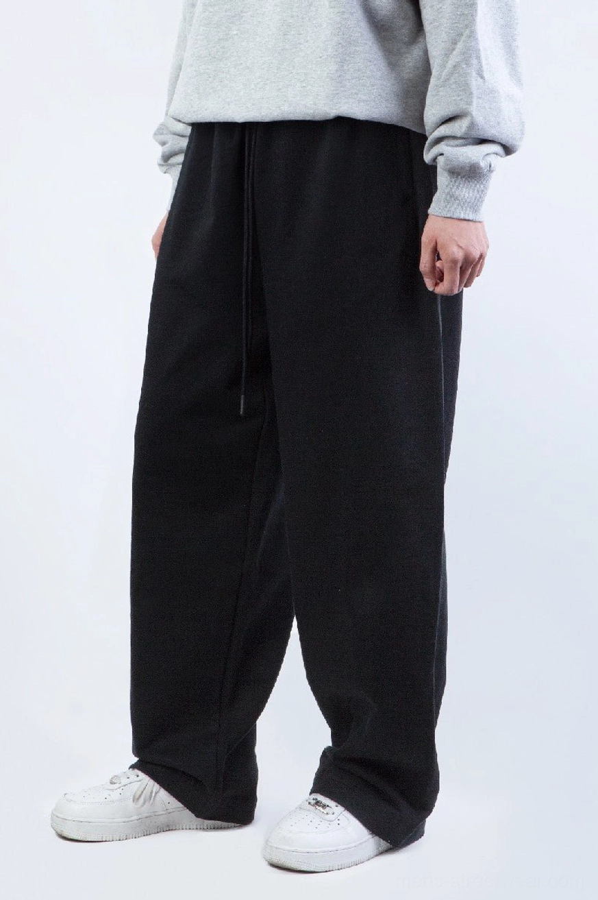 Black relaxed fit straight leg sweatpants side view showing draped wide leg Korean streetwear silhouette