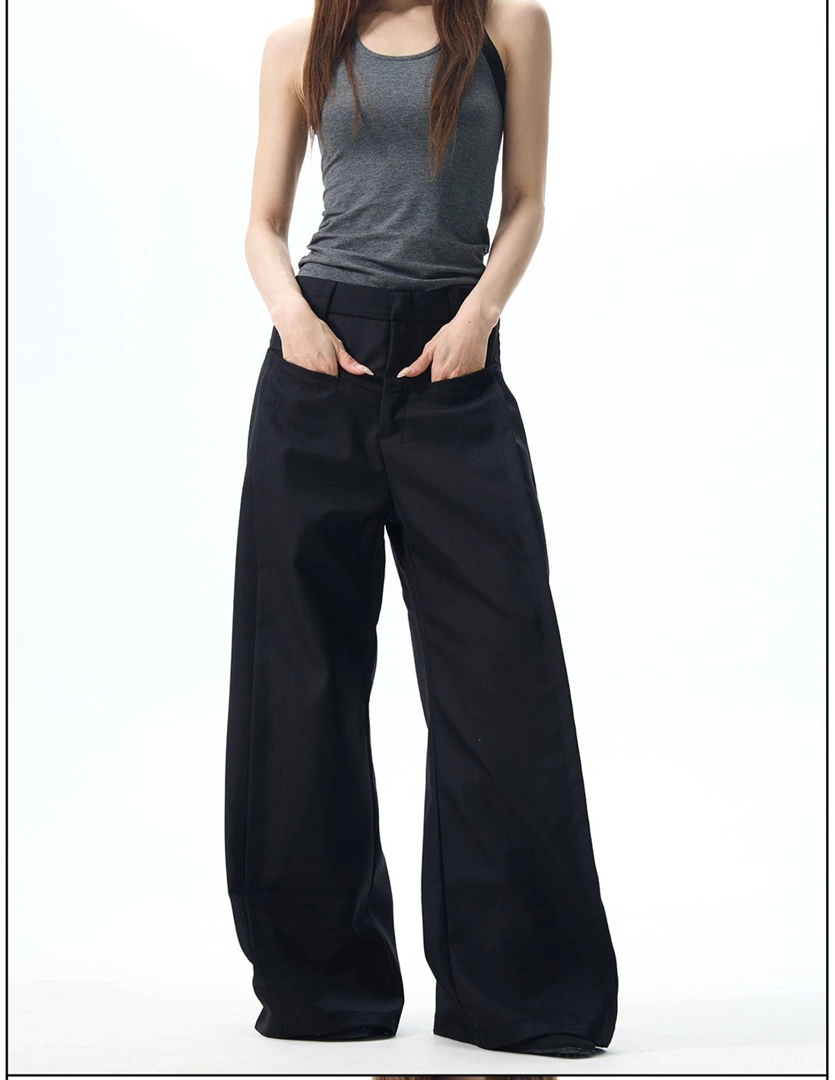 Three-quarter front view of black relaxed wide-leg pants with practical waist pockets and modern streetwear styling