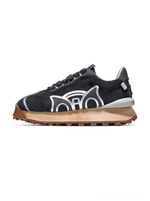 Black retro crest runner sneakers shown in left side profile with textured suede upper silver cat crest detail light gray midsole and gum brown outsole