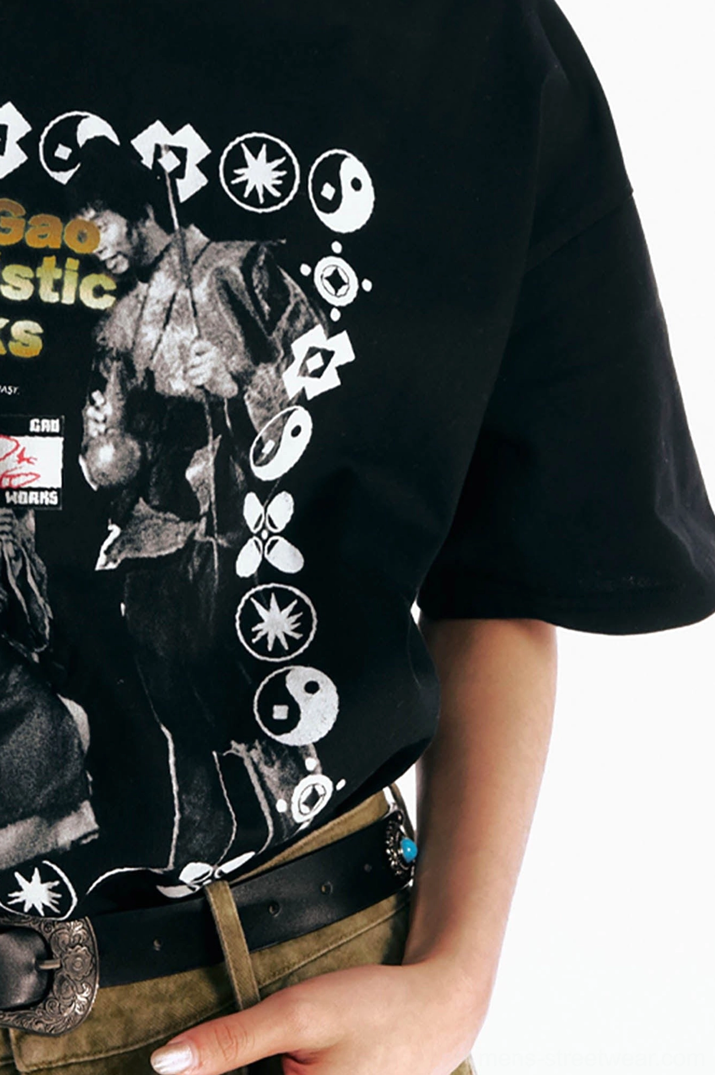 Close-up of black retro Hong Kong cinema graphic T-shirt hem and poster print styled with a leather belt and cargo pants