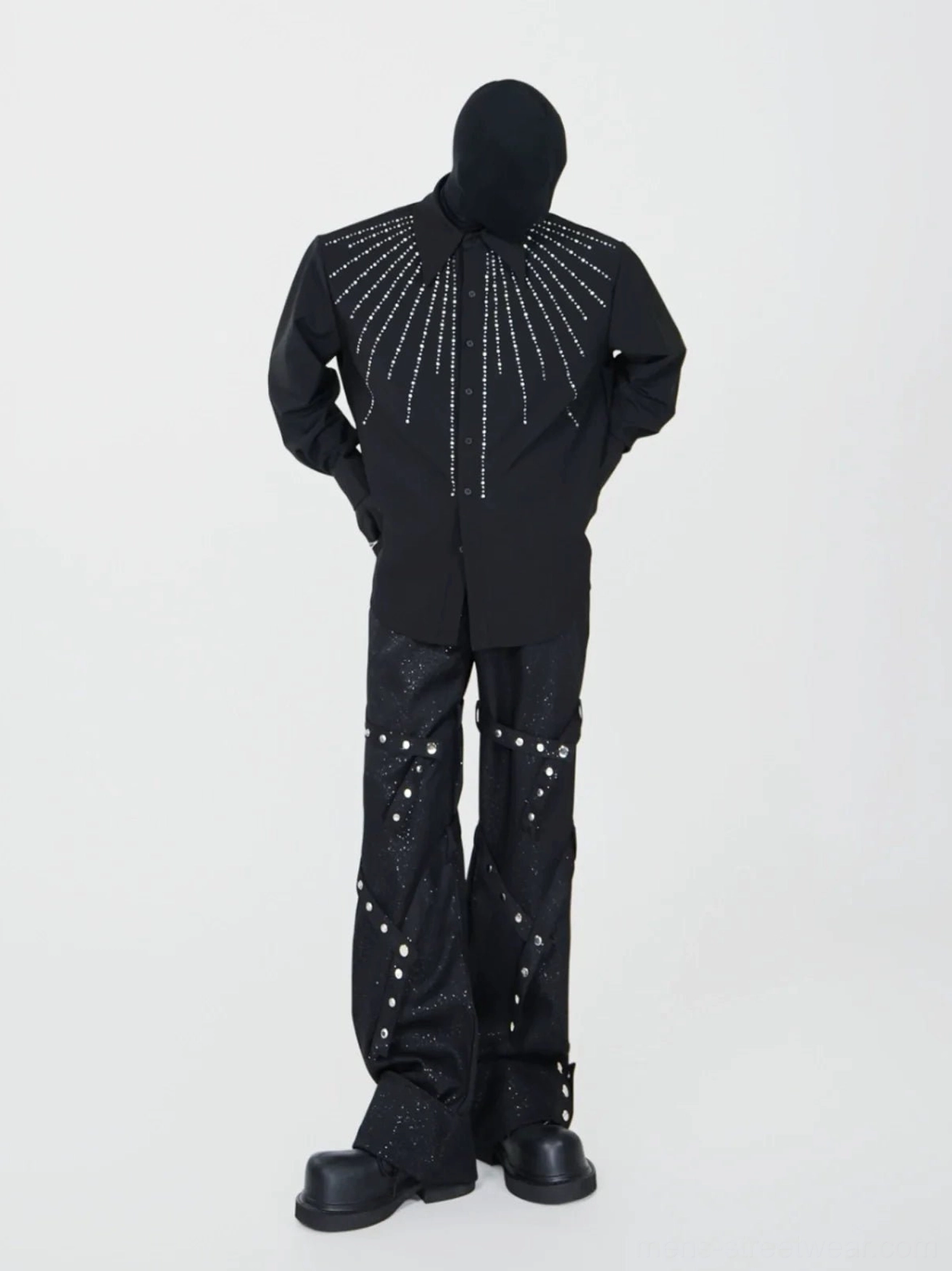 Full body black streetwear outfit featuring rivet spiral flare pants styled with a loose embellished shirt and platform shoes