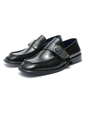Polished black leather loafers with sculpted square toe rose crest hardware and vivid blue leather lining on a white background