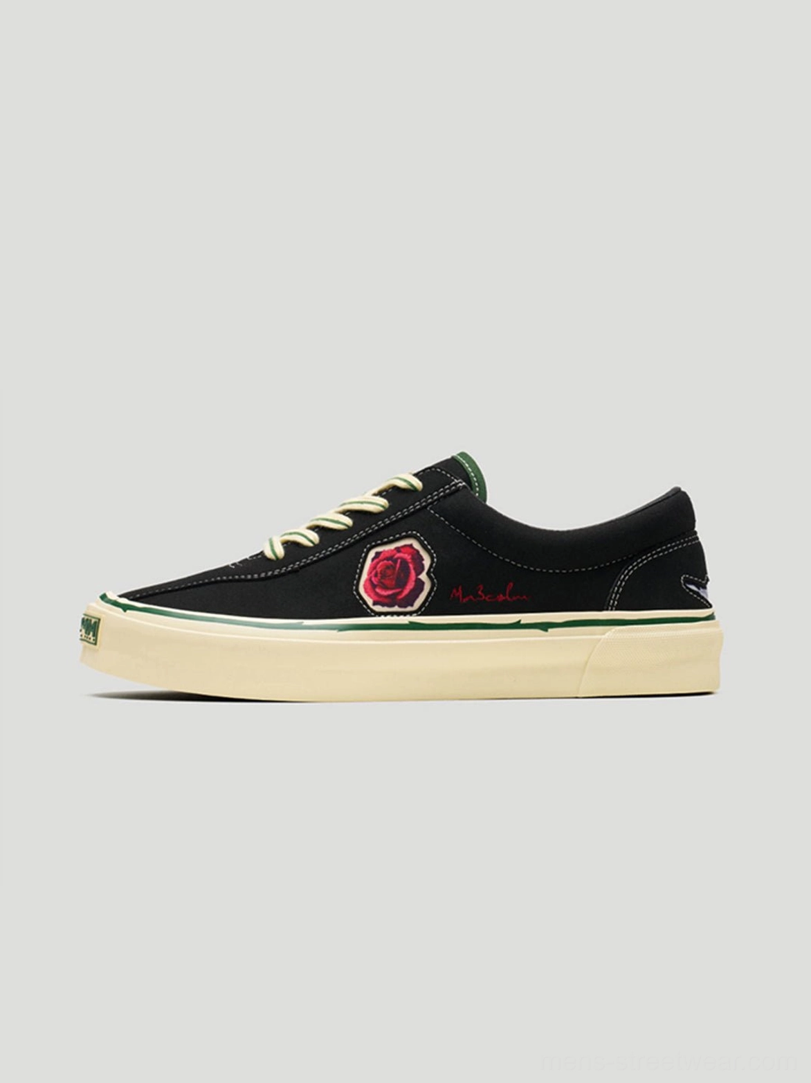 Black rose embroidered low-top skate shoes shown in left profile with contrast beige laces and an off-white vintage-tone rubber sole