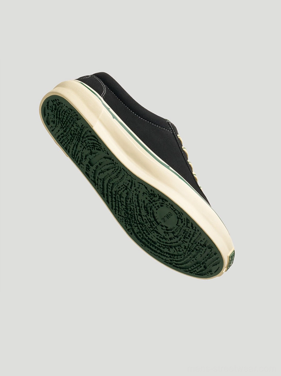 Three-quarter view of black rose embroidered skate shoes showing the off-white midsole and green patterned rubber outsole