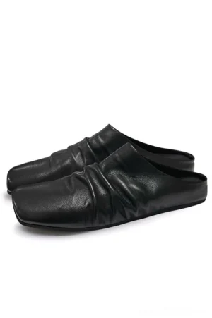Black ruched leather backless mules shown from a top side view with square toe and gathered vamp on a white studio background