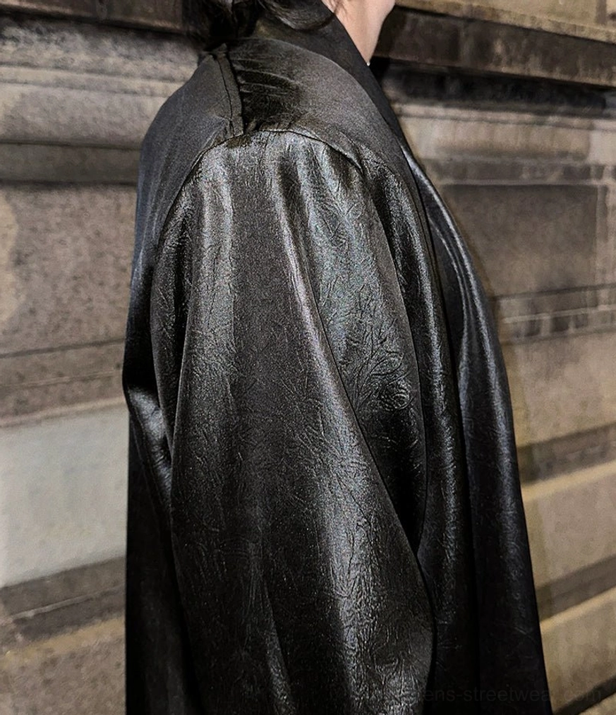 Close-up shoulder and back detail of black satin deep V-neck shirt with structured oversized draping