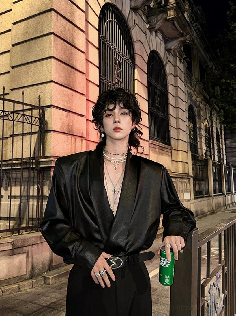 Black satin deep V-neck streetwear shirt shown from a three-quarter angle with layered necklaces and belt