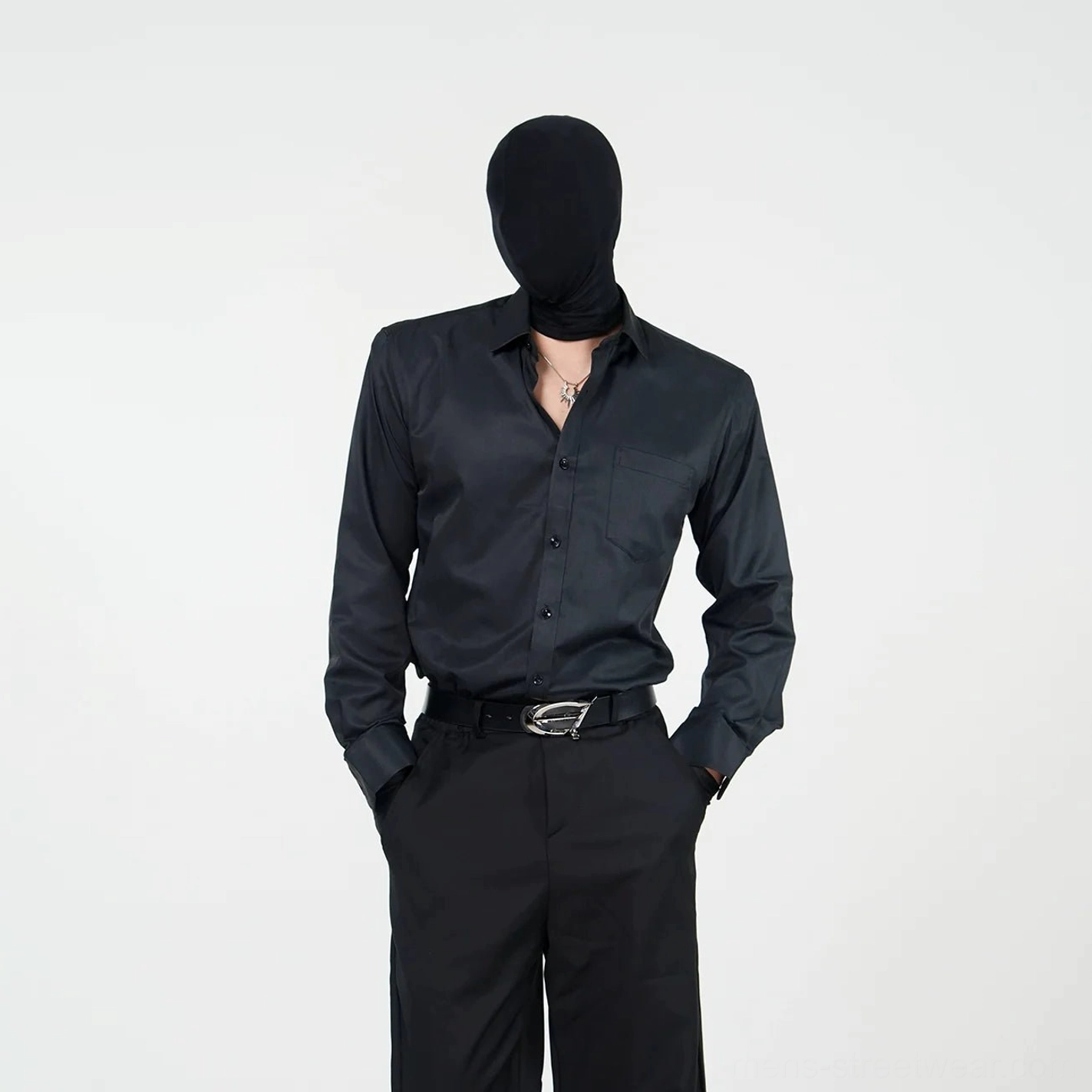 Black satin dress shirt with long sleeves, chest pocket, structured collar, and button front styled with black tailored trousers