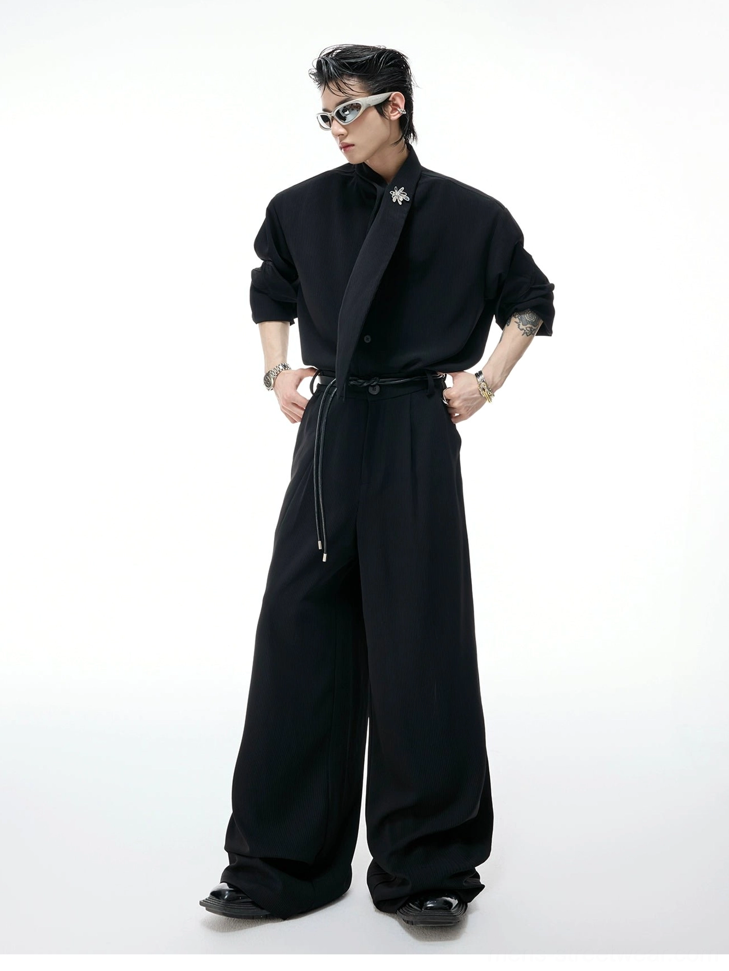 Black scarf collar wide-leg suit set styled on a male model in a minimalist studio with rolled sleeves, knotted stand collar, drawstring waist, and relaxed Korean streetwear tailoring