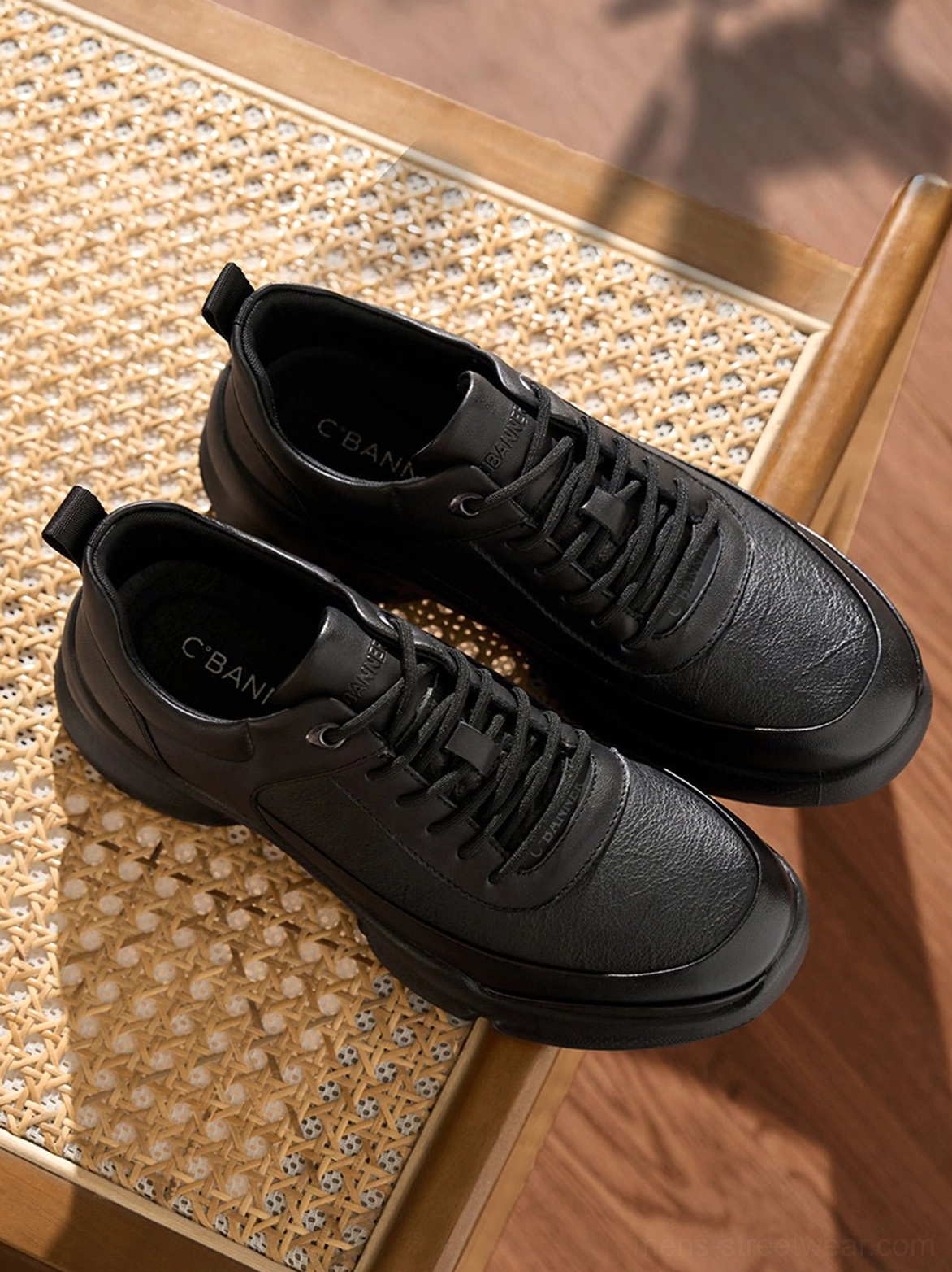 Angled top view of black chunky sneakers with tonal lace-up closure and sculpted athletic outsole