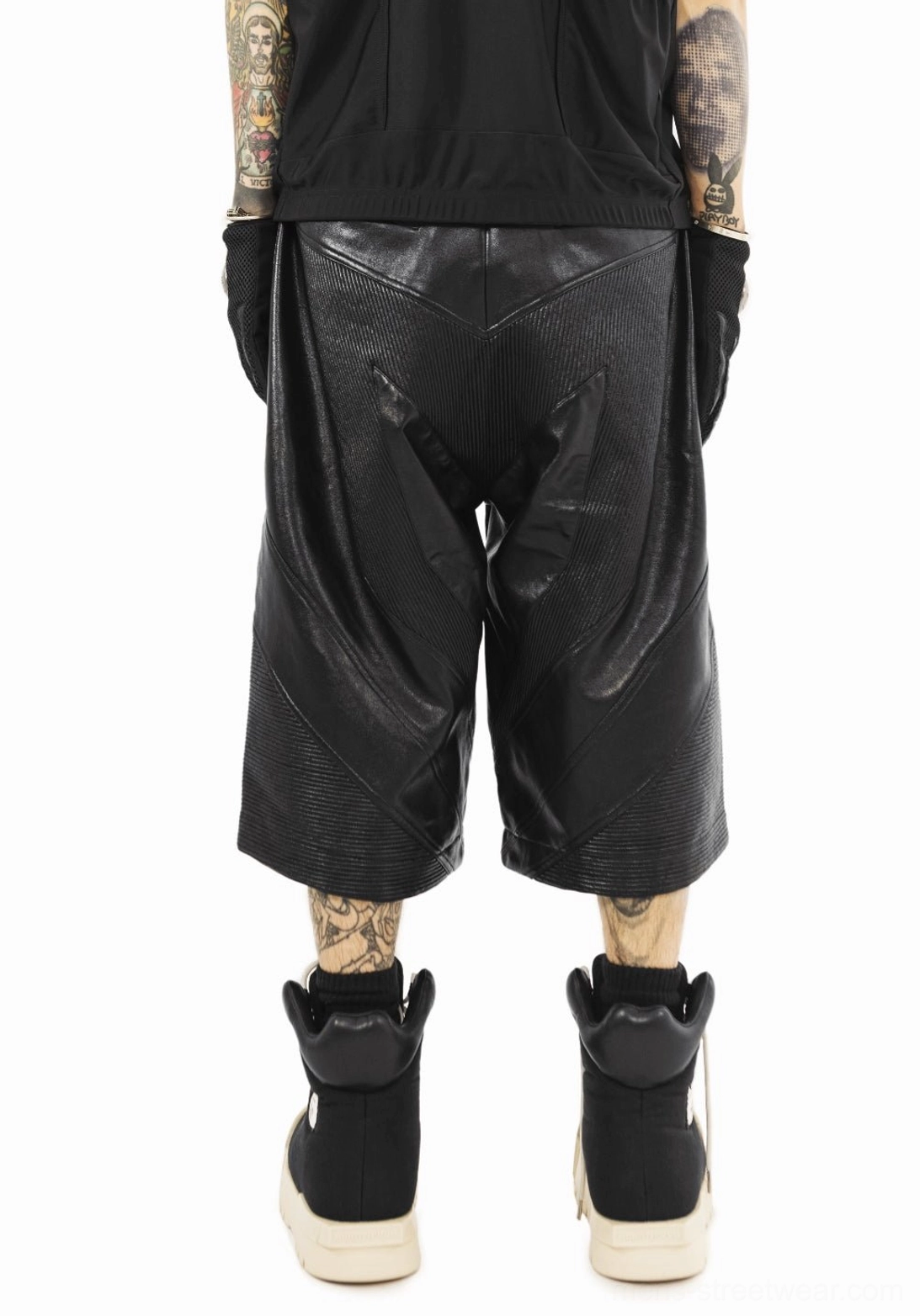 Full rear streetwear outfit view featuring black sculpted-toe platform high-top boots and cropped leather pants