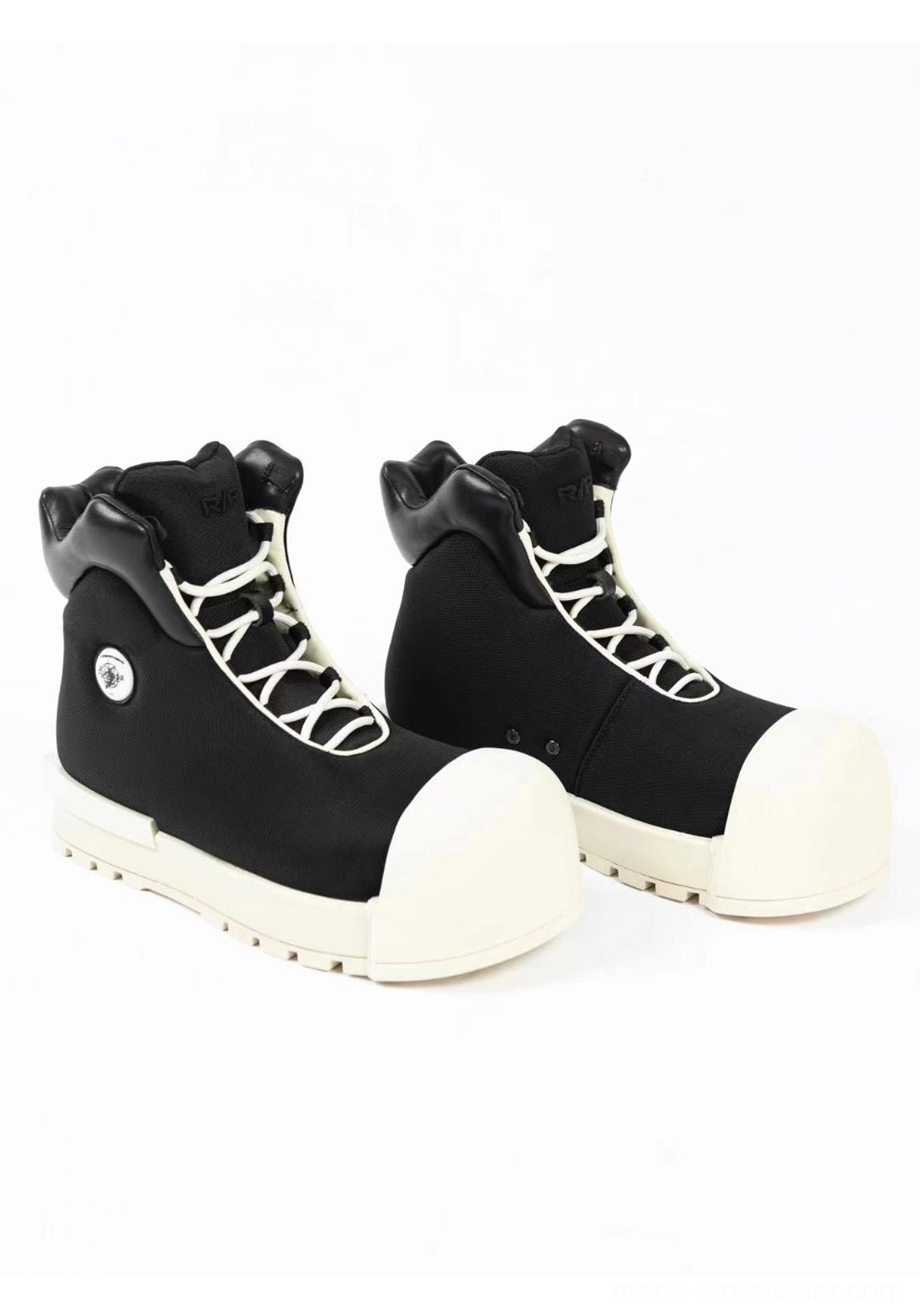 Pair of black sculpted-toe platform high-top boots with contrast off-white toe caps and elevated soles
