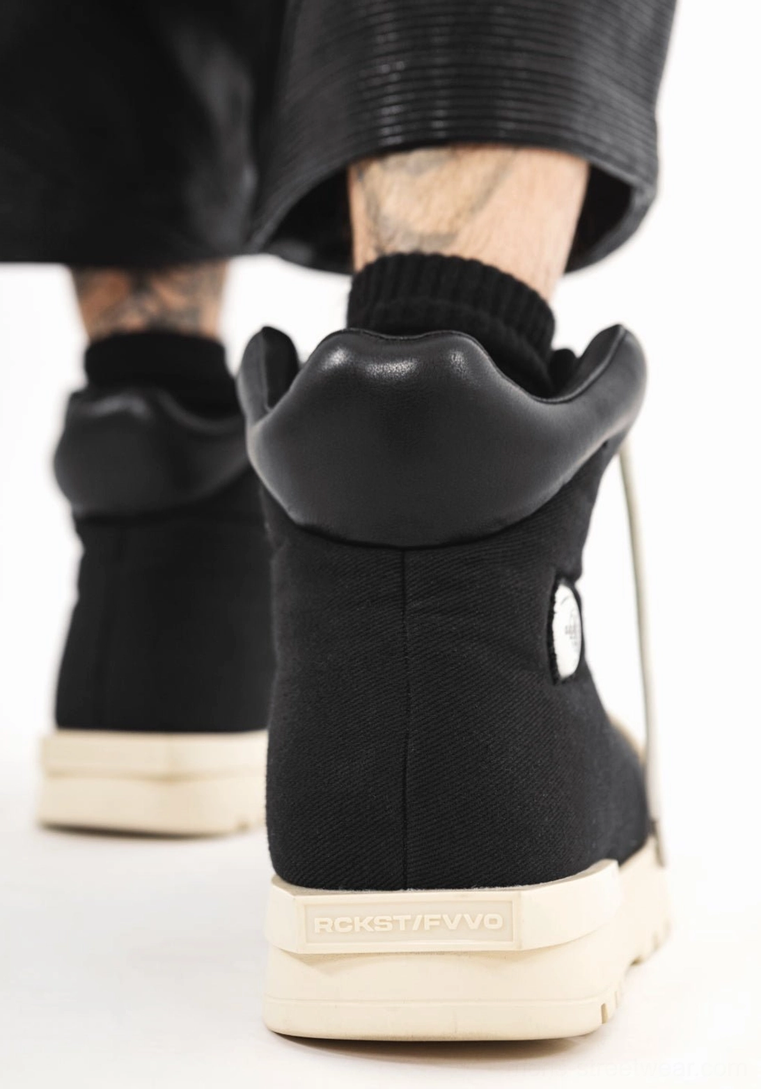 Rear view of black sculpted-toe platform high-top boots with padded collars and thick off-white platform soles