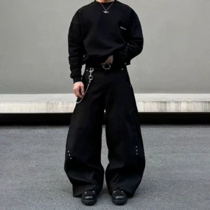 Black shadow rivet ultra wide-leg denim jeans shown from the front with curved seam panels and oversized streetwear silhouette