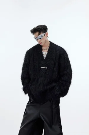 Black shaggy faux-fur V-neck sweater in an oversized Korean streetwear fit styled with silver sunglasses, layered necklace, and wide-leg leather pants